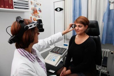 Eine Augenärztin untersucht die Netzhaut einer Patientin.